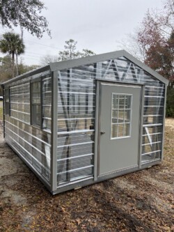 10x16 Greenhouse with Fan 9 Lite Door Electric Composite Floor Shelving Exterior Side View Gainesville FL, located in Gainesville, FL.
